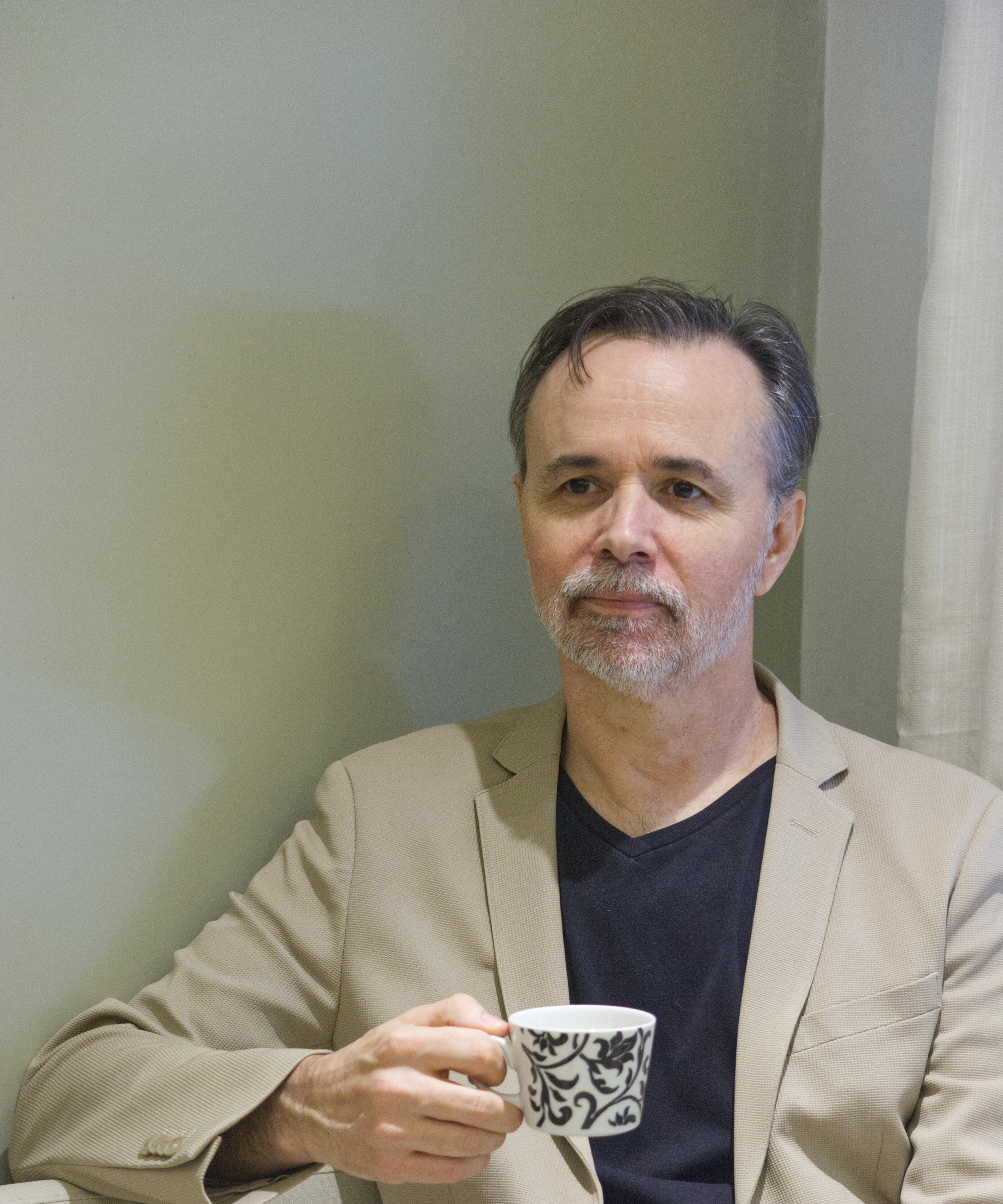 Dennis Warren holding a teacup during an individual English mentoring session.
